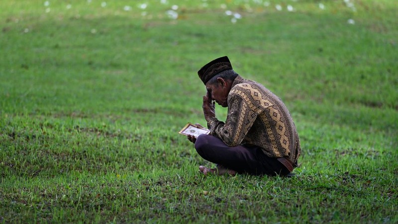 Seorang wanita berdoa di kuburan massal korban untuk memperingati 18 tahun tsunami Boxing Day 2004, di Banda Aceh pada 26 Desember 2022. (PCHAIDEER MAHYUDDIN / AFP)