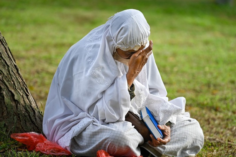 Seorang wanita berdoa di kuburan massal korban untuk memperingati 18 tahun tsunami Boxing Day 2004, di Banda Aceh pada 26 Desember 2022. Seorang wanita berdoa di kuburan massal korban untuk memperingati 18 tahun tsunami Boxing Day 2004, di Banda Aceh pada 26 Desember 2022. (PCHAIDEER MAHYUDDIN / AFP)