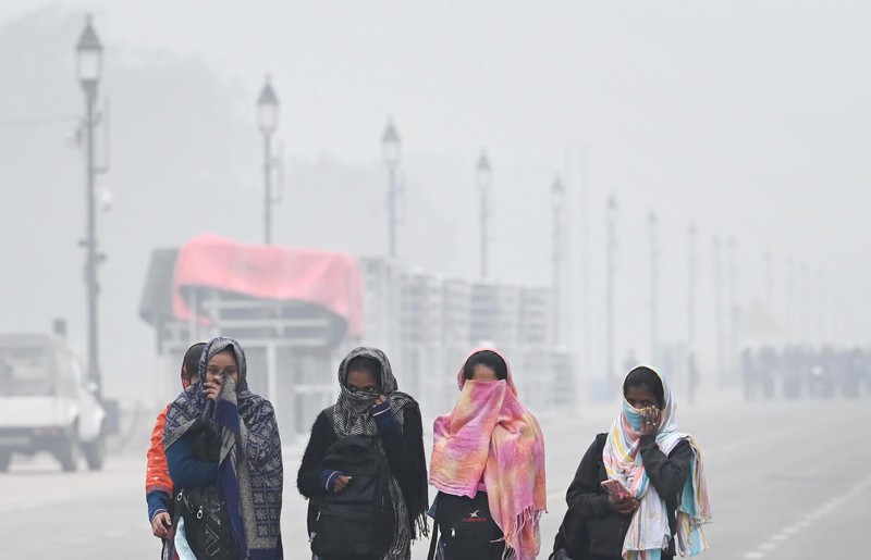 Orang-orang pergi ke tempat kerja mereka mengenakan pakaian hangat di tengah pagi kabut yang dingin dan tebal di sebuah jalan dekat Sekretariat Mini pada 26 Desember 2022 di Gurugram, India. Kabut tebal menyelimuti wilayah ibu kota nasional pada Senin pagi saat kota itu bergulat dengan kondisi gelombang dingin dengan suhu minimum yang cenderung turun hingga 4 derajat Celcius, menurut ramalan cuaca oleh Departemen Meteorologi India (IMD). (Photo by Parveen Kumar/Hindustan Times via Getty Images)