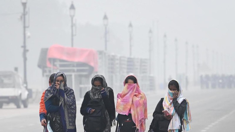 Orang-orang pergi ke tempat kerja mereka mengenakan pakaian hangat di tengah pagi kabut yang dingin dan tebal di sebuah jalan dekat Sekretariat Mini pada 26 Desember 2022 di Gurugram, India. Kabut tebal menyelimuti wilayah ibu kota nasional pada Senin pagi saat kota itu bergulat dengan kondisi gelombang dingin dengan suhu minimum yang cenderung turun hingga 4 derajat Celcius, menurut ramalan cuaca oleh Departemen Meteorologi India (IMD). (Photo by Parveen Kumar/Hindustan Times via Getty Images)