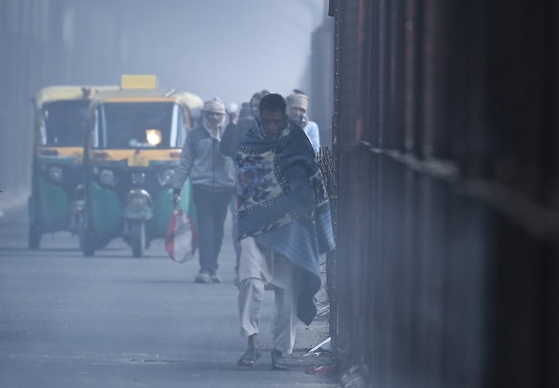 Kabut tebal menyelimuti wilayah ibu kota nasional pada Senin pagi saat kota itu bergulat dengan kondisi gelombang dingin dengan suhu minimum yang cenderung turun hingga 4 derajat Celcius, menurut ramalan cuaca oleh Departemen Meteorologi India (IMD). Orang-orang pergi ke tempat kerja mereka mengenakan pakaian hangat di tengah pagi kabut yang dingin dan tebal di sebuah jalan dekat Sekretariat Mini pada 26 Desember 2022 di Gurugram, India. Kabut tebal menyelimuti wilayah ibu kota nasional pada Senin pagi saat kota itu bergulat dengan kondisi gelombang dingin dengan suhu minimum yang cenderung turun hingga 4 derajat Celcius, menurut ramalan cuaca oleh Departemen Meteorologi India (IMD). (Photo by Parveen Kumar/Hindustan Times via Getty Images)
