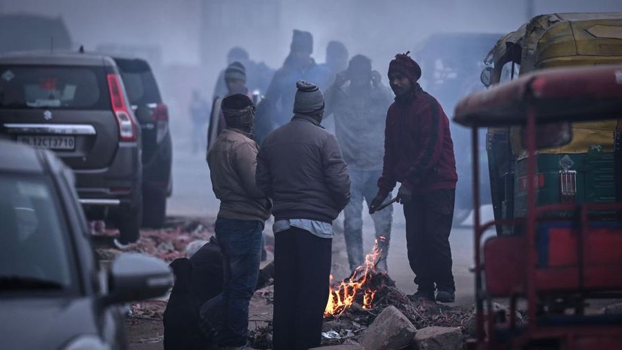 Orang-orang pergi ke tempat kerja mereka mengenakan pakaian hangat di tengah pagi kabut yang dingin dan tebal di sebuah jalan dekat Sekretariat Mini pada 26 Desember 2022 di Gurugram, India. Kabut tebal menyelimuti wilayah ibu kota nasional pada Senin pagi saat kota itu bergulat dengan kondisi gelombang dingin dengan suhu minimum yang cenderung turun hingga 4 derajat Celcius, menurut ramalan cuaca oleh Departemen Meteorologi India (IMD). (Photo by Parveen Kumar/Hindustan Times via Getty Images)