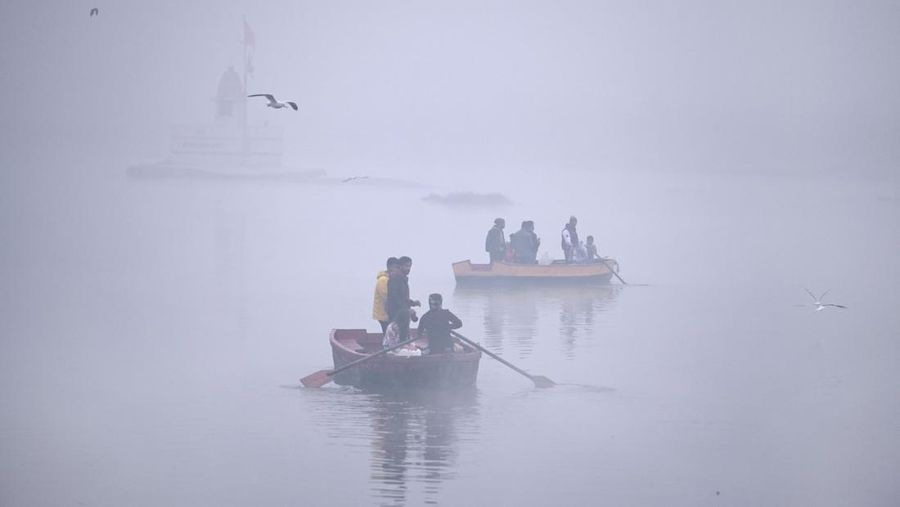 Seorang pria duduk di perahu memberi makan burung camar di Sungai Yamuna saat pagi yang dingin dan berkabut pada 26 Desember 2022 di New Delhi, India. Kabut tebal menyelimuti wilayah ibu kota nasional pada Senin pagi saat kota itu bergulat dengan kondisi gelombang dingin dengan suhu minimum yang cenderung turun hingga 4 derajat Celcius, menurut ramalan cuaca oleh Departemen Meteorologi India (IMD). (Photo by Raj K Raj/Hindustan Times via Getty Images)