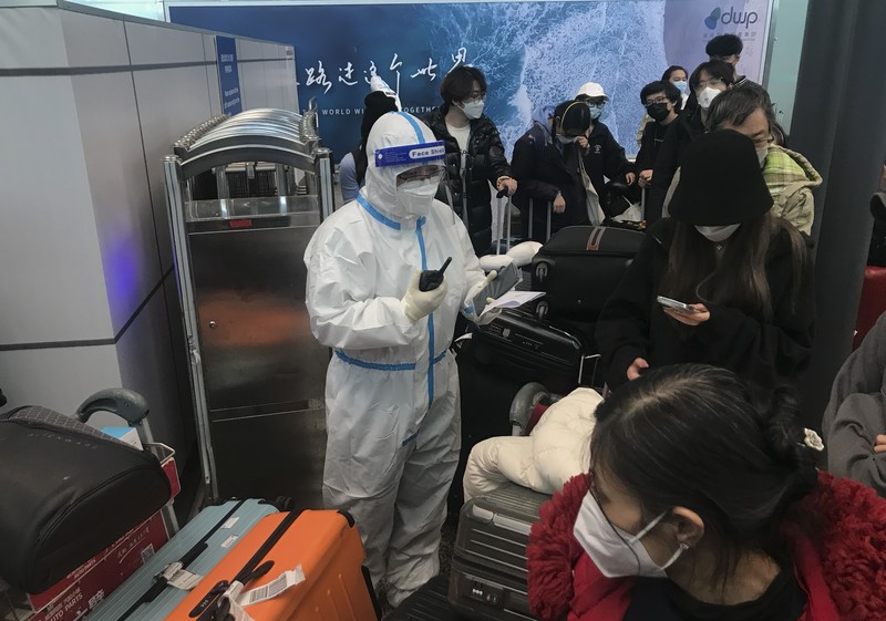 Pelancong yang masuk menunggu berjam-jam untuk naik bus untuk berangkat ke hotel dan fasilitas karantina dari Bandara Guangzhou Baiyun di provinsi Guangdong, China selatan pada 25 Desember 2022. China akan mencabut persyaratan karantina COVID-19 untuk penumpang yang datang dari luar negeri mulai 8 Januari 2020. Komisi Kesehatan Nasional mengumumkan pada Senin, 26 Desember 2022 dalam pelonggaran terbaru dari langkah-langkah pengendalian virus yang dulu ketat di negara itu. (AP Photo/Emily Wang Fujiyama)