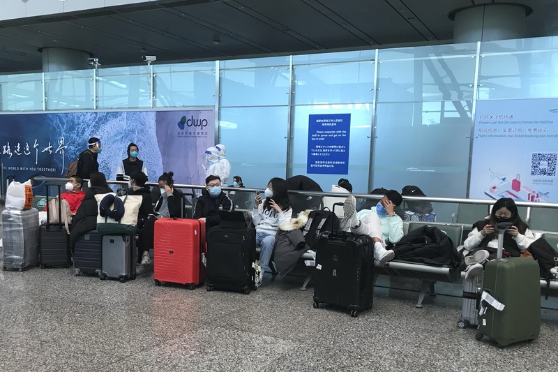 Pelancong yang masuk menunggu berjam-jam untuk naik bus untuk berangkat ke hotel dan fasilitas karantina dari Bandara Guangzhou Baiyun di provinsi Guangdong, China selatan pada 25 Desember 2022. China akan mencabut persyaratan karantina COVID-19 untuk penumpang yang datang dari luar negeri mulai 8 Januari 2020. Komisi Kesehatan Nasional mengumumkan pada Senin, 26 Desember 2022 dalam pelonggaran terbaru dari langkah-langkah pengendalian virus yang dulu ketat di negara itu. (AP Photo/Emily Wang Fujiyama)