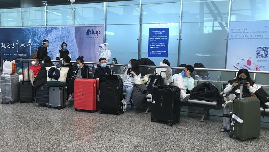 Pelancong yang masuk menunggu berjam-jam untuk naik bus untuk berangkat ke hotel dan fasilitas karantina dari Bandara Guangzhou Baiyun di provinsi Guangdong, China selatan pada 25 Desember 2022. China akan mencabut persyaratan karantina COVID-19 untuk penumpang yang datang dari luar negeri mulai 8 Januari 2020. Komisi Kesehatan Nasional mengumumkan pada Senin, 26 Desember 2022 dalam pelonggaran terbaru dari langkah-langkah pengendalian virus yang dulu ketat di negara itu. (AP Photo/Emily Wang Fujiyama)