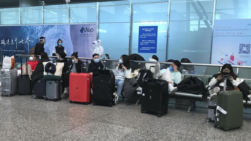 Pelancong yang masuk menunggu berjam-jam untuk naik bus untuk berangkat ke hotel dan fasilitas karantina dari Bandara Guangzhou Baiyun di provinsi Guangdong, China selatan pada 25 Desember 2022. China akan mencabut persyaratan karantina COVID-19 untuk penumpang yang datang dari luar negeri mulai 8 Januari 2020. Komisi Kesehatan Nasional mengumumkan pada Senin, 26 Desember 2022 dalam pelonggaran terbaru dari langkah-langkah pengendalian virus yang dulu ketat di negara itu. (AP Photo/Emily Wang Fujiyama)