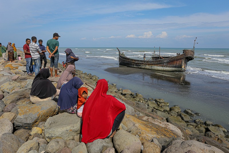 Pengungsi Rohingya menerima perawatan medis darurat setelah sebuah kapal yang membawa hampir 200 orang mendarat di Indonesia pada 26 Desember, kata pihak berwenang, dalam pendaratan keempat di negara tersebut dalam beberapa bulan terakhir. Foto yang diambil pada 26 Desember 2022 ini memperlihatkan para pria Rohingya sedang beristirahat di sebuah penampungan di distrik Muara Tiga di Pidie, provinsi Aceh. - Pengungsi Rohingya menerima perawatan medis darurat setelah sebuah kapal yang membawa hampir 200 orang mendarat di Indonesia pada 26 Desember, kata pihak berwenang, dalam pendaratan keempat di negara tersebut dalam beberapa bulan terakhir. (AMANDA JUFRIAN/AFP via Getty Images)