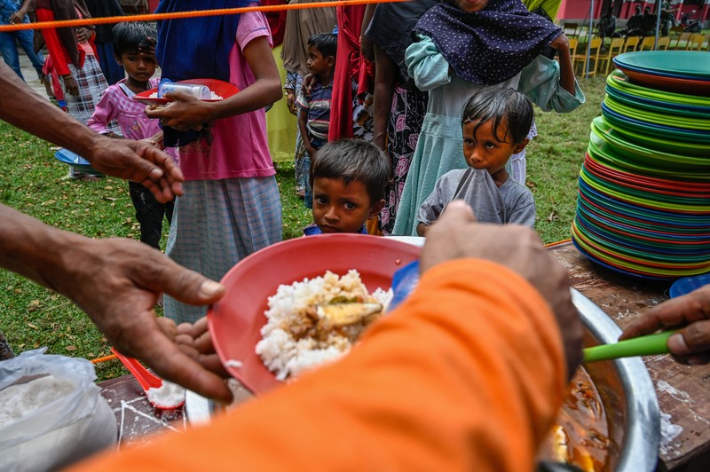 Foto yang diambil pada 26 Desember 2022 ini memperlihatkan para pria Rohingya sedang beristirahat di sebuah penampungan di distrik Muara Tiga di Pidie, provinsi Aceh. - Pengungsi Rohingya menerima perawatan medis darurat setelah sebuah kapal yang membawa hampir 200 orang mendarat di Indonesia pada 26 Desember, kata pihak berwenang, dalam pendaratan keempat di negara tersebut dalam beberapa bulan terakhir. (AMANDA JUFRIAN/AFP via Getty Images)