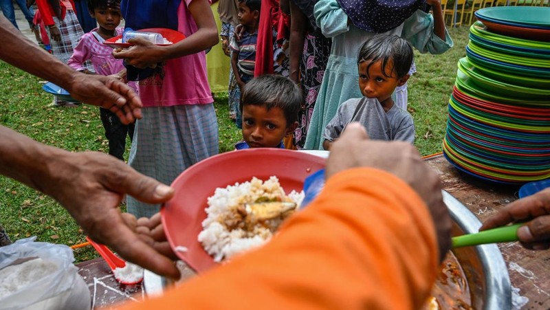 Foto yang diambil pada 26 Desember 2022 ini memperlihatkan para pria Rohingya sedang beristirahat di sebuah penampungan di distrik Muara Tiga di Pidie, provinsi Aceh. - Pengungsi Rohingya menerima perawatan medis darurat setelah sebuah kapal yang membawa hampir 200 orang mendarat di Indonesia pada 26 Desember, kata pihak berwenang, dalam pendaratan keempat di negara tersebut dalam beberapa bulan terakhir. (AMANDA JUFRIAN/AFP via Getty Images)