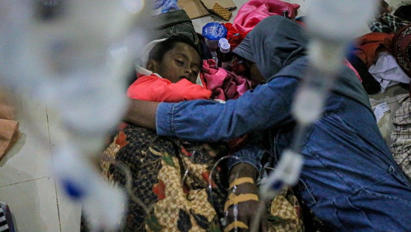Foto yang diambil pada 26 Desember 2022 ini memperlihatkan para pria Rohingya sedang beristirahat di sebuah penampungan di distrik Muara Tiga di Pidie, provinsi Aceh. - Pengungsi Rohingya menerima perawatan medis darurat setelah sebuah kapal yang membawa hampir 200 orang mendarat di Indonesia pada 26 Desember, kata pihak berwenang, dalam pendaratan keempat di negara tersebut dalam beberapa bulan terakhir. (AMANDA JUFRIAN/AFP via Getty Images)