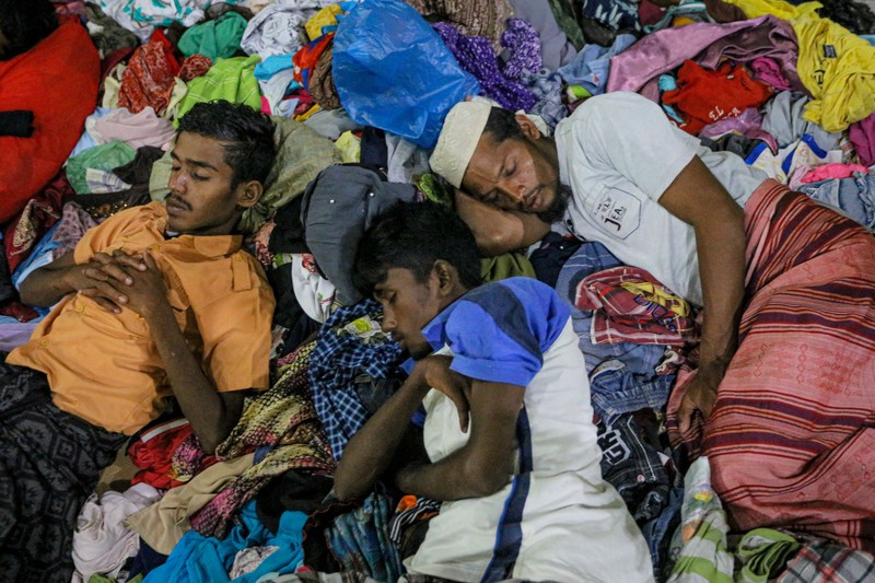 Pengungsi Rohingya menerima perawatan medis darurat setelah sebuah kapal yang membawa hampir 200 orang mendarat di Indonesia pada 26 Desember, kata pihak berwenang, dalam pendaratan keempat di negara tersebut dalam beberapa bulan terakhir. Foto yang diambil pada 26 Desember 2022 ini memperlihatkan para pria Rohingya sedang beristirahat di sebuah penampungan di distrik Muara Tiga di Pidie, provinsi Aceh. - Pengungsi Rohingya menerima perawatan medis darurat setelah sebuah kapal yang membawa hampir 200 orang mendarat di Indonesia pada 26 Desember, kata pihak berwenang, dalam pendaratan keempat di negara tersebut dalam beberapa bulan terakhir. (AMANDA JUFRIAN/AFP via Getty Images)