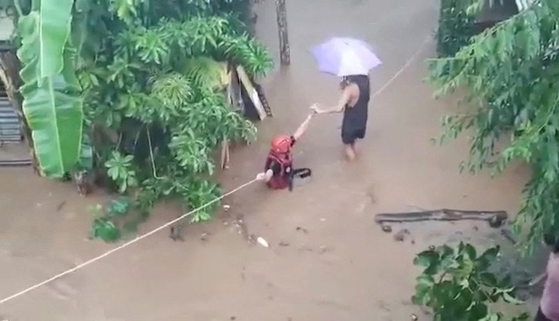 Petugas penyelamat membantu korban banjir di Plaridel, Misamis Occidental Province, Filipina, (26/12/2022). (via REUTERS/PHILIPPINE COAST GUARD)
