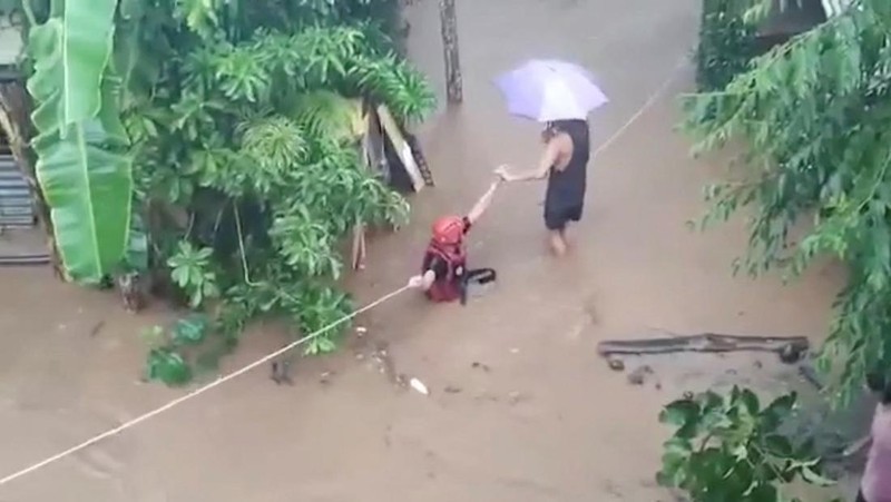 Petugas penyelamat membantu korban banjir di Plaridel, Misamis Occidental Province, Filipina, (26/12/2022). (via REUTERS/PHILIPPINE COAST GUARD)