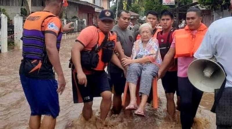 Petugas penyelamat membantu korban banjir di Plaridel, Misamis Occidental Province, Filipina, (26/12/2022). (via REUTERS/PHILIPPINE COAST GUARD)