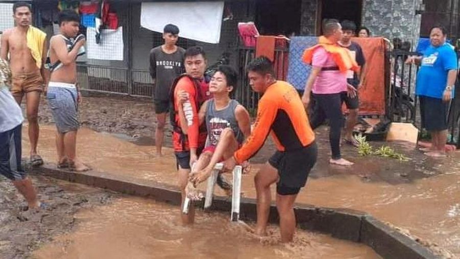 Petugas penyelamat membantu korban banjir di Plaridel, Misamis Occidental Province, Filipina, (26/12/2022). (via REUTERS/PHILIPPINE COAST GUARD)