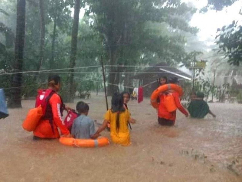 Petugas penyelamat membantu korban banjir di Plaridel, Misamis Occidental Province, Filipina, (26/12/2022). (via REUTERS/PHILIPPINE COAST GUARD)