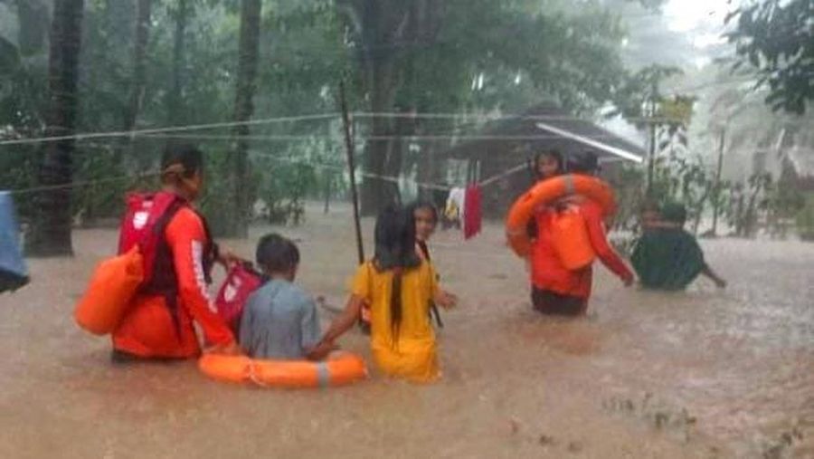 Petugas penyelamat membantu korban banjir di Plaridel, Misamis Occidental Province, Filipina, (26/12/2022). (via REUTERS/PHILIPPINE COAST GUARD)