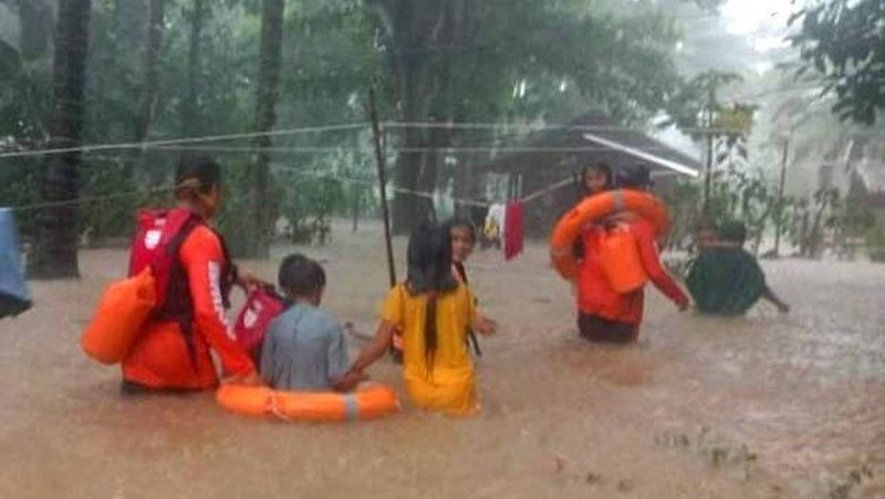 Petugas penyelamat membantu korban banjir di Plaridel, Misamis Occidental Province, Filipina, (26/12/2022). (via REUTERS/PHILIPPINE COAST GUARD)