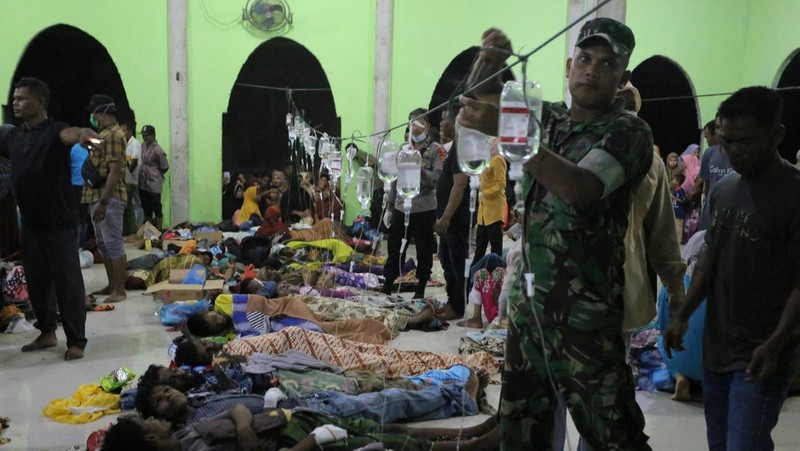 Foto yang diambil pada 26 Desember 2022 ini memperlihatkan para pria Rohingya sedang beristirahat di sebuah penampungan di distrik Muara Tiga di Pidie, provinsi Aceh. - Pengungsi Rohingya menerima perawatan medis darurat setelah sebuah kapal yang membawa hampir 200 orang mendarat di Indonesia pada 26 Desember, kata pihak berwenang, dalam pendaratan keempat di negara tersebut dalam beberapa bulan terakhir. (AMANDA JUFRIAN/AFP via Getty Images)