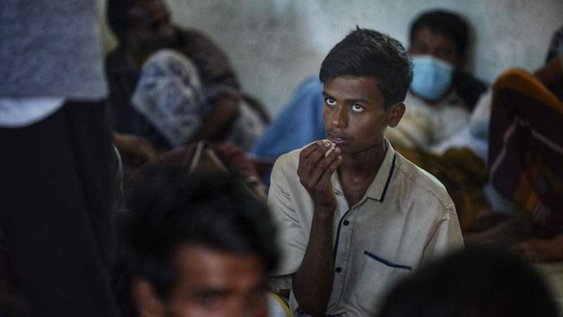 Foto yang diambil pada 26 Desember 2022 ini memperlihatkan para pria Rohingya sedang beristirahat di sebuah penampungan di distrik Muara Tiga di Pidie, provinsi Aceh. - Pengungsi Rohingya menerima perawatan medis darurat setelah sebuah kapal yang membawa hampir 200 orang mendarat di Indonesia pada 26 Desember, kata pihak berwenang, dalam pendaratan keempat di negara tersebut dalam beberapa bulan terakhir. (AMANDA JUFRIAN/AFP via Getty Images)