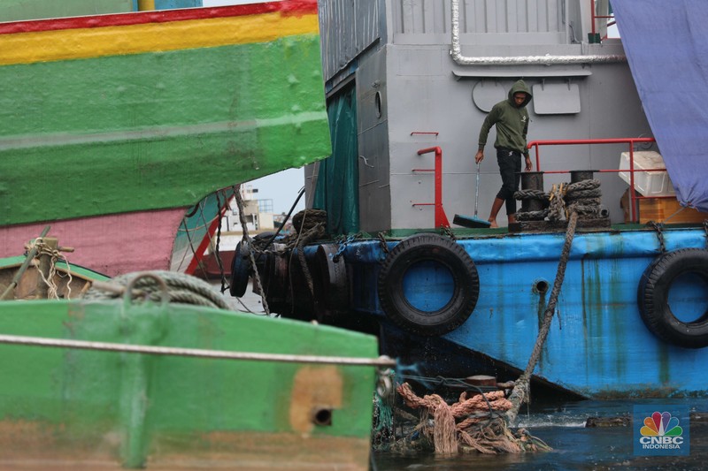 Banjir Rob di Pelabuhan Muara Baru, Anak Buah Kapal (ABK) melintasi banjir rob saat cuaca buruk di Pelabuhan Muara Baru, Penjaringan, Jakarta Utara, Rabu (28/12/2022). Badan Meteorologi Klimatologi dan Geofisika (BMKG) menyampaikan ada potensi cuaca ekstrem terjadi di sejumlah wilayah di Indonesia. (CNBC Indonesia/ Muhammad Sabki)