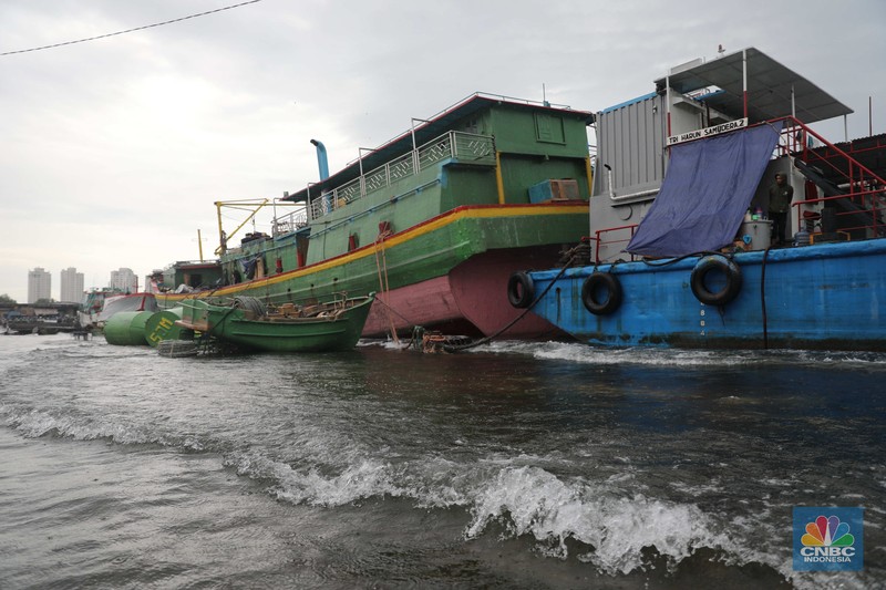 Banjir Rob di Pelabuhan Muara Baru, Anak Buah Kapal (ABK) melintasi banjir rob saat cuaca buruk di Pelabuhan Muara Baru, Penjaringan, Jakarta Utara, Rabu (28/12/2022). Badan Meteorologi Klimatologi dan Geofisika (BMKG) menyampaikan ada potensi cuaca ekstrem terjadi di sejumlah wilayah di Indonesia. (CNBC Indonesia/ Muhammad Sabki)