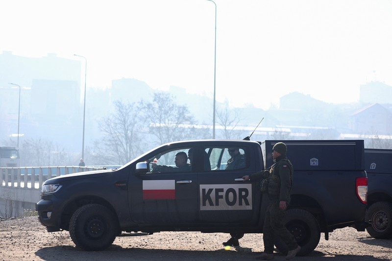 Tentara Italia yang bertugas dalam misi penjaga perdamaian internasional yang dipimpin NATO di Kosovo berpatroli di dekat jalan yang dibarikade dengan truk oleh warga Serbia di desa Rudare dekat kota Zvecan, Kosovo, Senin (26/12/2022).  Sejak November, Kosovo bergejolak usai ratusan pekerja etnis Serbia ramai-ramai mengundurkan diri. Mereka memprotes keputusan kontroversial pemerintah Kosovo yang melarang orang Serbia di negara itu menggunakan plat nomor dari Beograd. (Photo by ARMEND NIMANI/AFP via Getty Images)