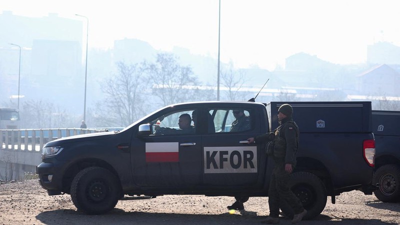 Tentara Italia yang bertugas dalam misi penjaga perdamaian internasional yang dipimpin NATO di Kosovo berpatroli di dekat jalan yang dibarikade dengan truk oleh warga Serbia di desa Rudare dekat kota Zvecan, Kosovo, Senin (26/12/2022).  Sejak November, Kosovo bergejolak usai ratusan pekerja etnis Serbia ramai-ramai mengundurkan diri. Mereka memprotes keputusan kontroversial pemerintah Kosovo yang melarang orang Serbia di negara itu menggunakan plat nomor dari Beograd. (Photo by ARMEND NIMANI/AFP via Getty Images)