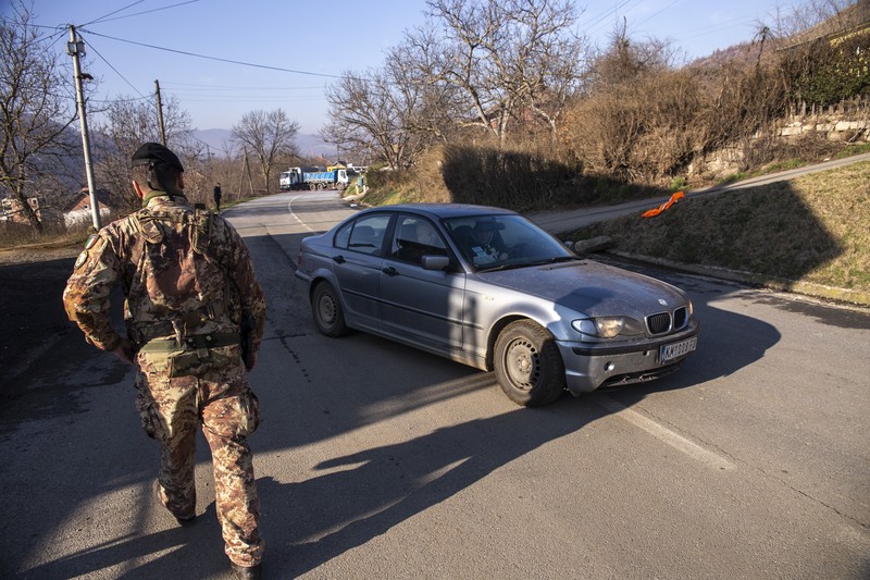 Tentara Italia yang bertugas dalam misi penjaga perdamaian internasional yang dipimpin NATO di Kosovo berpatroli di dekat jalan yang dibarikade dengan truk oleh warga Serbia di desa Rudare dekat kota Zvecan, Kosovo, Senin (26/12/2022).  Sejak November, Kosovo bergejolak usai ratusan pekerja etnis Serbia ramai-ramai mengundurkan diri. Mereka memprotes keputusan kontroversial pemerintah Kosovo yang melarang orang Serbia di negara itu menggunakan plat nomor dari Beograd. (Photo by ARMEND NIMANI/AFP via Getty Images)
