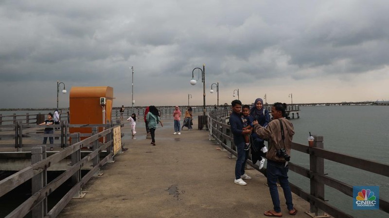 Sejumlah pengunjung beraktivitas di Pantai Festival Ancol, Jakarta Utara, Rabu (28/12/2022). BRIN memprediksi Jabodetabek bakal dilanda cuaca buruk pada 28 Desember. (CNBC Indonesia/ Muhammad Sabki)