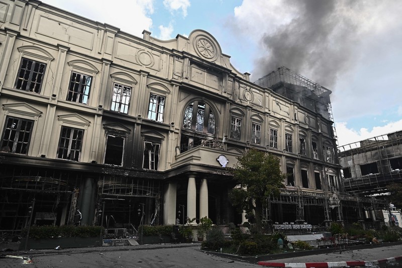 Tim paramedis berjalan melalui bagian kasino hotel Grand Diamond City yang terbakar setelah kebakaran besar di kompleks tersebut, di Poipet di provinsi Banteay Meanchey pada 30 Desember 2022. Tim paramedis berjalan melalui bagian kasino hotel Grand Diamond City yang terbakar setelah kebakaran besar di kompleks tersebut, di Poipet di provinsi Banteay Meanchey pada 30 Desember 2022. - Setidaknya 19 orang tewas dan banyak lainnya dikhawatirkan tewas dalam kebakaran di kasino Kamboja, kata para pejabat, dengan seorang penyelamat menggambarkan bagaimana para korban melemparkan diri mereka dari langkan dalam upaya putus asa untuk melarikan diri dari api. (TANG CHHIN SOTHY/AFP via Getty Images)