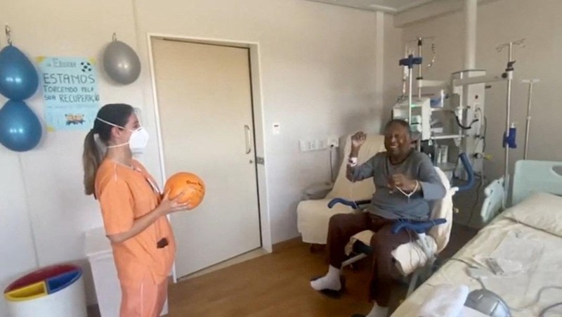 Seorang pengunjung melihat foto legenda sepak bola Brasil Edson Arantes do Nascimento 'Pele', dipamerkan di Pele Museum, di Santos, Brasil, pada 27 Desember 2022. (AFP via Getty Images/NELSON ALMEIDA)