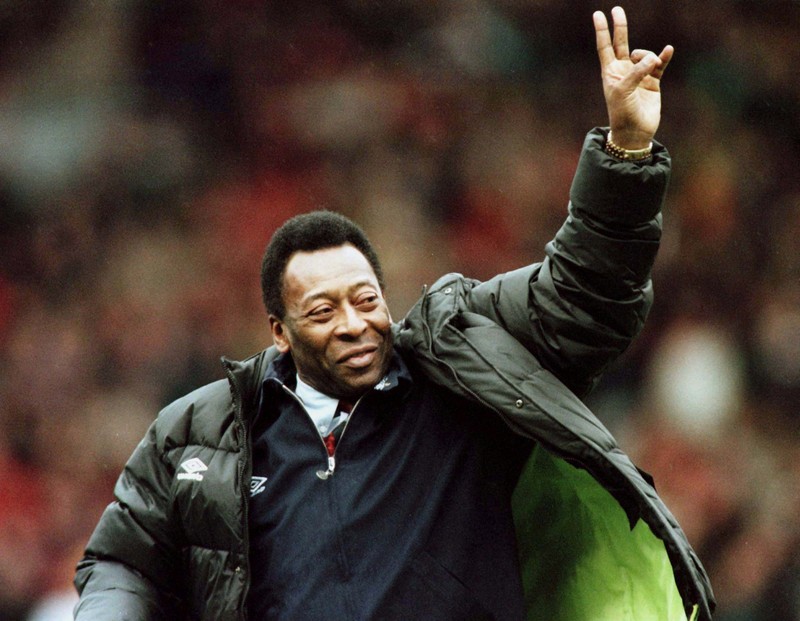 Seorang pengunjung melihat foto legenda sepak bola Brasil Edson Arantes do Nascimento 'Pele', dipamerkan di Pele Museum, di Santos, Brasil, pada 27 Desember 2022. (AFP via Getty Images/NELSON ALMEIDA)