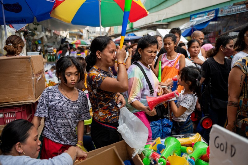 Orang-orang berbelanja di pasar umum menjelang perayaan Tahun Baru, di Manila, Filipina, 30 Desember 2022. (REUTERS/Lisa Marie David)