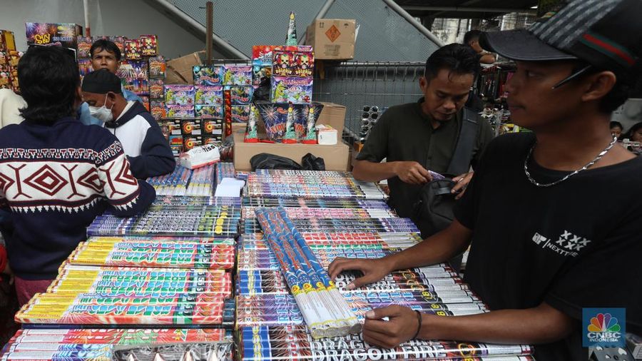 Pedagang melayani pembeli kembang api yang dijual di kawasan pasar Asemka, Jakarta Barat, Jumat (30/12/2022). Jelang perayaan tahun baru penjualan kembang api meningkat. Kembang api berbagai jenis itu dijual dengan harga beragam. (CNBC Indonesia/Andrean Kristianto)