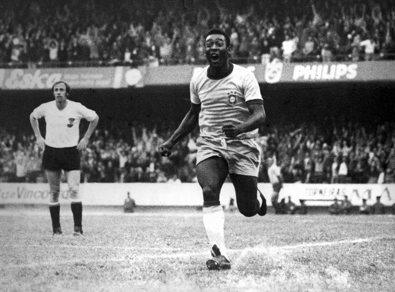 Seorang pengunjung melihat foto legenda sepak bola Brasil Edson Arantes do Nascimento 'Pele', dipamerkan di Pele Museum, di Santos, Brasil, pada 27 Desember 2022. (AFP via Getty Images/NELSON ALMEIDA)