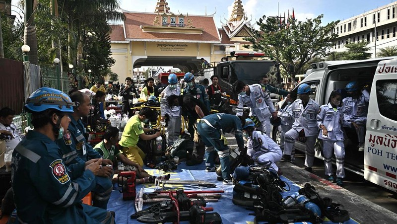 Tim paramedis berjalan melalui bagian kasino hotel Grand Diamond City yang terbakar setelah kebakaran besar di kompleks tersebut, di Poipet di provinsi Banteay Meanchey pada 30 Desember 2022. - Setidaknya 19 orang tewas dan banyak lainnya dikhawatirkan tewas dalam kebakaran di kasino Kamboja, kata para pejabat, dengan seorang penyelamat menggambarkan bagaimana para korban melemparkan diri mereka dari langkan dalam upaya putus asa untuk melarikan diri dari api. (TANG CHHIN SOTHY/AFP via Getty Images)