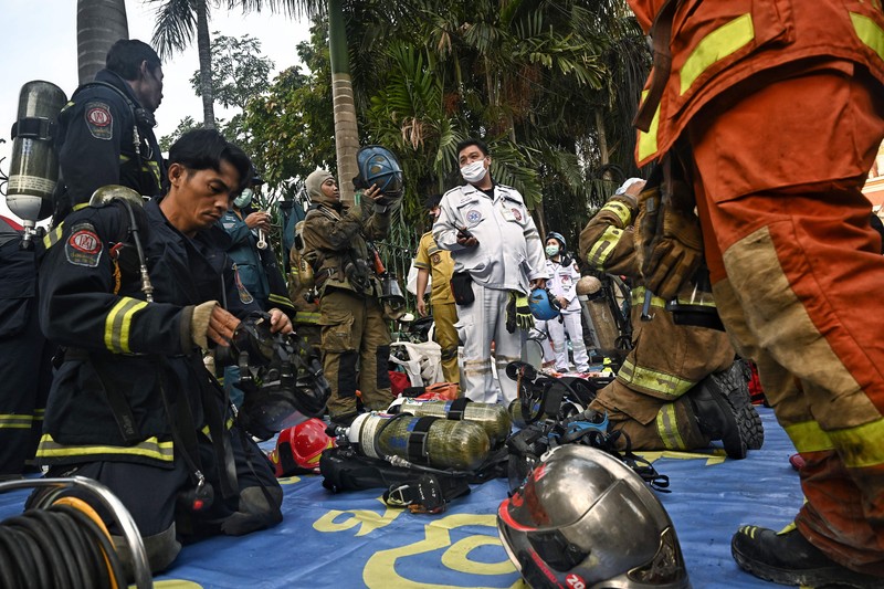 Tim paramedis berjalan melalui bagian kasino hotel Grand Diamond City yang terbakar setelah kebakaran besar di kompleks tersebut, di Poipet di provinsi Banteay Meanchey pada 30 Desember 2022. Tim paramedis berjalan melalui bagian kasino hotel Grand Diamond City yang terbakar setelah kebakaran besar di kompleks tersebut, di Poipet di provinsi Banteay Meanchey pada 30 Desember 2022. - Setidaknya 19 orang tewas dan banyak lainnya dikhawatirkan tewas dalam kebakaran di kasino Kamboja, kata para pejabat, dengan seorang penyelamat menggambarkan bagaimana para korban melemparkan diri mereka dari langkan dalam upaya putus asa untuk melarikan diri dari api. (TANG CHHIN SOTHY/AFP via Getty Images)