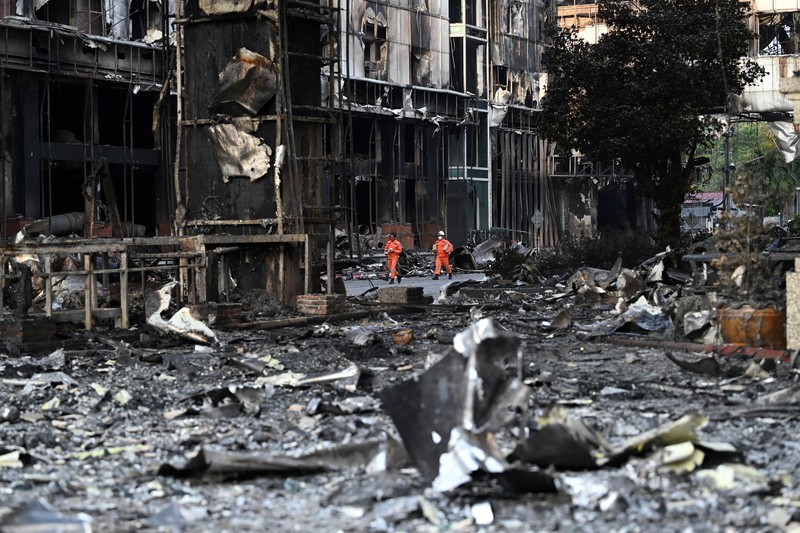 Tim paramedis berjalan melalui bagian kasino hotel Grand Diamond City yang terbakar setelah kebakaran besar di kompleks tersebut, di Poipet di provinsi Banteay Meanchey pada 30 Desember 2022. Tim paramedis berjalan melalui bagian kasino hotel Grand Diamond City yang terbakar setelah kebakaran besar di kompleks tersebut, di Poipet di provinsi Banteay Meanchey pada 30 Desember 2022. - Setidaknya 19 orang tewas dan banyak lainnya dikhawatirkan tewas dalam kebakaran di kasino Kamboja, kata para pejabat, dengan seorang penyelamat menggambarkan bagaimana para korban melemparkan diri mereka dari langkan dalam upaya putus asa untuk melarikan diri dari api. (TANG CHHIN SOTHY/AFP via Getty Images)