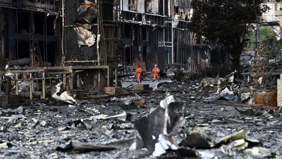 Tim paramedis berjalan melalui bagian kasino hotel Grand Diamond City yang terbakar setelah kebakaran besar di kompleks tersebut, di Poipet di provinsi Banteay Meanchey pada 30 Desember 2022. - Setidaknya 19 orang tewas dan banyak lainnya dikhawatirkan tewas dalam kebakaran di kasino Kamboja, kata para pejabat, dengan seorang penyelamat menggambarkan bagaimana para korban melemparkan diri mereka dari langkan dalam upaya putus asa untuk melarikan diri dari api. (TANG CHHIN SOTHY/AFP via Getty Images)