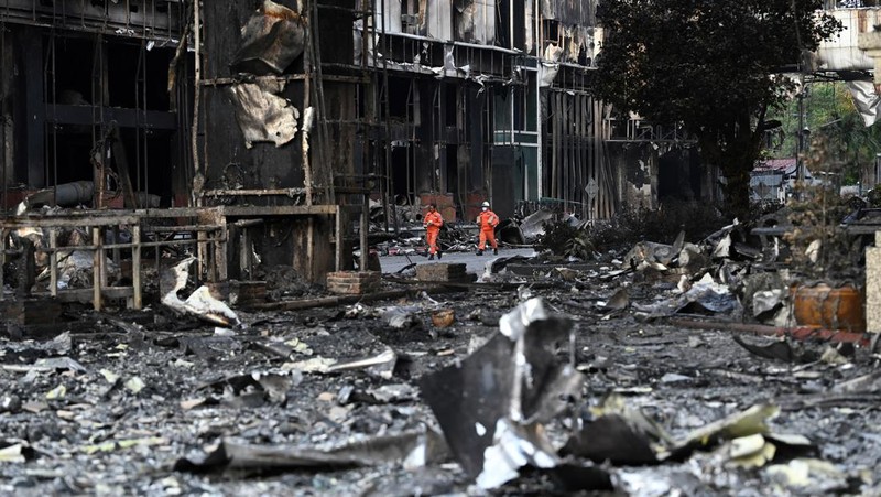 Tim paramedis berjalan melalui bagian kasino hotel Grand Diamond City yang terbakar setelah kebakaran besar di kompleks tersebut, di Poipet di provinsi Banteay Meanchey pada 30 Desember 2022. - Setidaknya 19 orang tewas dan banyak lainnya dikhawatirkan tewas dalam kebakaran di kasino Kamboja, kata para pejabat, dengan seorang penyelamat menggambarkan bagaimana para korban melemparkan diri mereka dari langkan dalam upaya putus asa untuk melarikan diri dari api. (TANG CHHIN SOTHY/AFP via Getty Images)