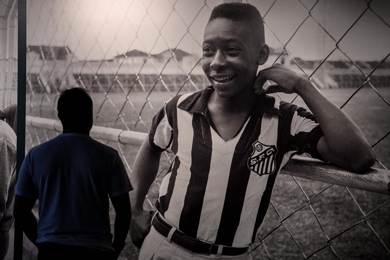 Seorang pengunjung melihat foto legenda sepak bola Brasil Edson Arantes do Nascimento 'Pele', dipamerkan di Pele Museum, di Santos, Brasil, pada 27 Desember 2022. (AFP via Getty Images/NELSON ALMEIDA)