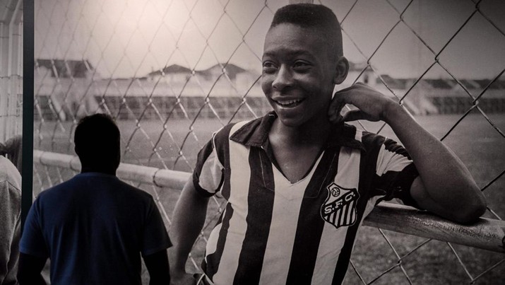 Seorang pengunjung melihat foto legenda sepak bola Brasil Edson Arantes do Nascimento 'Pele', dipamerkan di Pele Museum, di Santos, Brasil, pada 27 Desember 2022. (AFP via Getty Images/NELSON ALMEIDA)