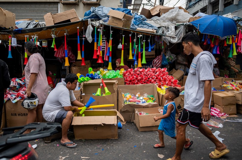Orang-orang berbelanja di pasar umum menjelang perayaan Tahun Baru, di Manila, Filipina, 30 Desember 2022. Orang-orang berbelanja di pasar umum menjelang perayaan Tahun Baru, di Manila, Filipina, 30 Desember 2022. (REUTERS/Lisa Marie David)