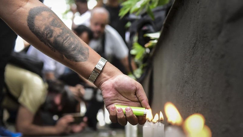 Seorang pengunjung melihat foto legenda sepak bola Brasil Edson Arantes do Nascimento 'Pele', dipamerkan di Pele Museum, di Santos, Brasil, pada 27 Desember 2022. (AFP via Getty Images/NELSON ALMEIDA)