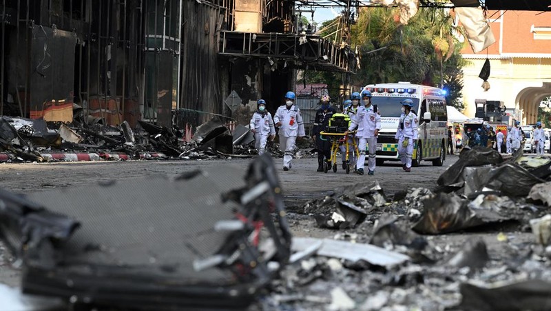 Tim paramedis berjalan melalui bagian kasino hotel Grand Diamond City yang terbakar setelah kebakaran besar di kompleks tersebut, di Poipet di provinsi Banteay Meanchey pada 30 Desember 2022. - Setidaknya 19 orang tewas dan banyak lainnya dikhawatirkan tewas dalam kebakaran di kasino Kamboja, kata para pejabat, dengan seorang penyelamat menggambarkan bagaimana para korban melemparkan diri mereka dari langkan dalam upaya putus asa untuk melarikan diri dari api. (TANG CHHIN SOTHY/AFP via Getty Images)