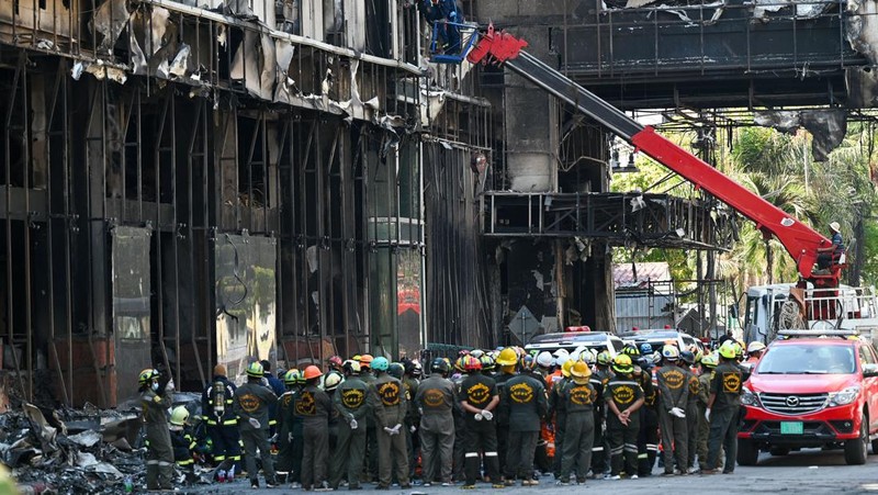 Tim paramedis berjalan melalui bagian kasino hotel Grand Diamond City yang terbakar setelah kebakaran besar di kompleks tersebut, di Poipet di provinsi Banteay Meanchey pada 30 Desember 2022. - Setidaknya 19 orang tewas dan banyak lainnya dikhawatirkan tewas dalam kebakaran di kasino Kamboja, kata para pejabat, dengan seorang penyelamat menggambarkan bagaimana para korban melemparkan diri mereka dari langkan dalam upaya putus asa untuk melarikan diri dari api. (TANG CHHIN SOTHY/AFP via Getty Images)