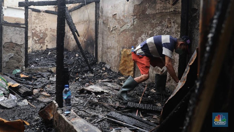 Warga membawa barang yang masih bisa diselamatkan di pemukiman yang terbakar di Jalan Bangka Buntu, Mampang Prapatan, Jakarta, Jumat (30/12/2022). (վ/Muhammad Sabki)