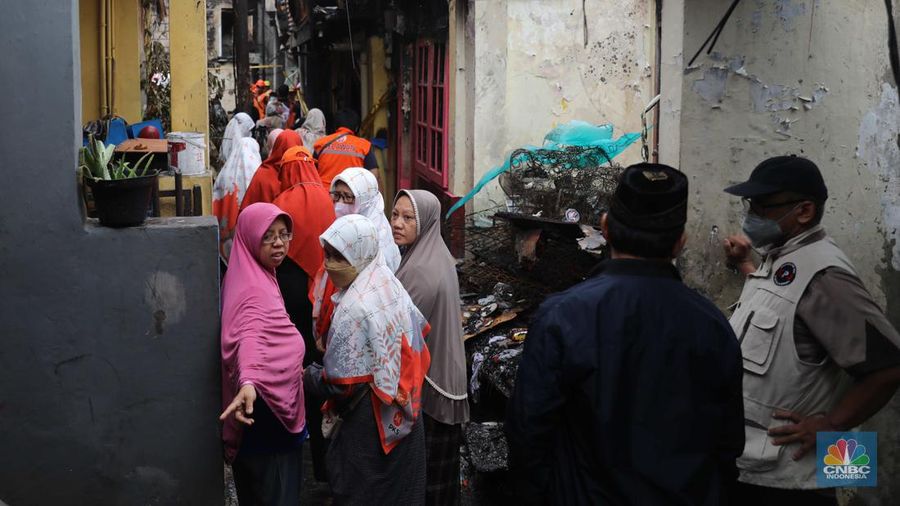 Warga membawa barang yang masih bisa diselamatkan di pemukiman yang terbakar di Jalan Bangka Buntu, Mampang Prapatan, Jakarta, Jumat (30/12/2022). (վ/Muhammad Sabki)